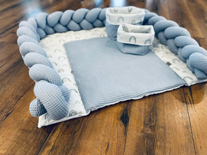 Weiße Wickelauflage von Mein Shop, Teil der BILDERGALERIE Wickelsets, auf weichem Untergrund für Babys.