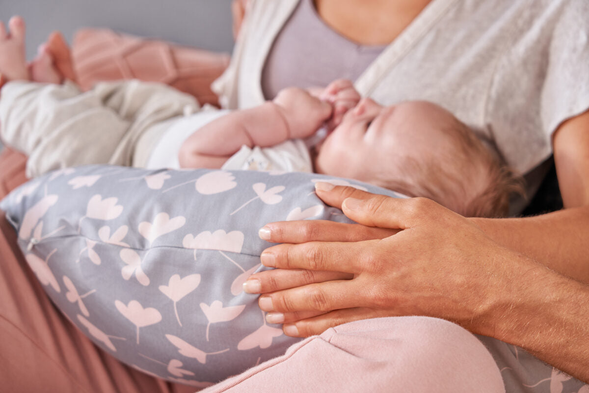 Theraline Stillkissen mit individuellem Bezug, modell auf einem Bett, ergonomisch geformt für Komfort beim Stillen.